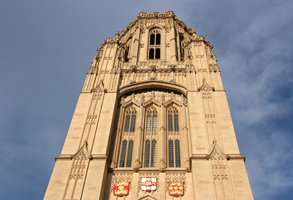 An image looking up at the Tower of Wills Memorial building against menacing grey skies