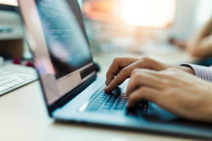 male hands typing on a keyboard laptop