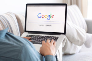 Man sitting at a laptop about to Google search