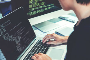 A software developer sits at a computer writing code, find out more development news in our Development Edition of OWID