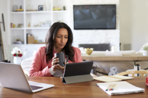 A woman holds a cup of coffee while working from home - check out our open-souce tools to help you work from home