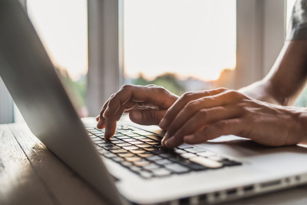 A person types on an apple macbook laptop