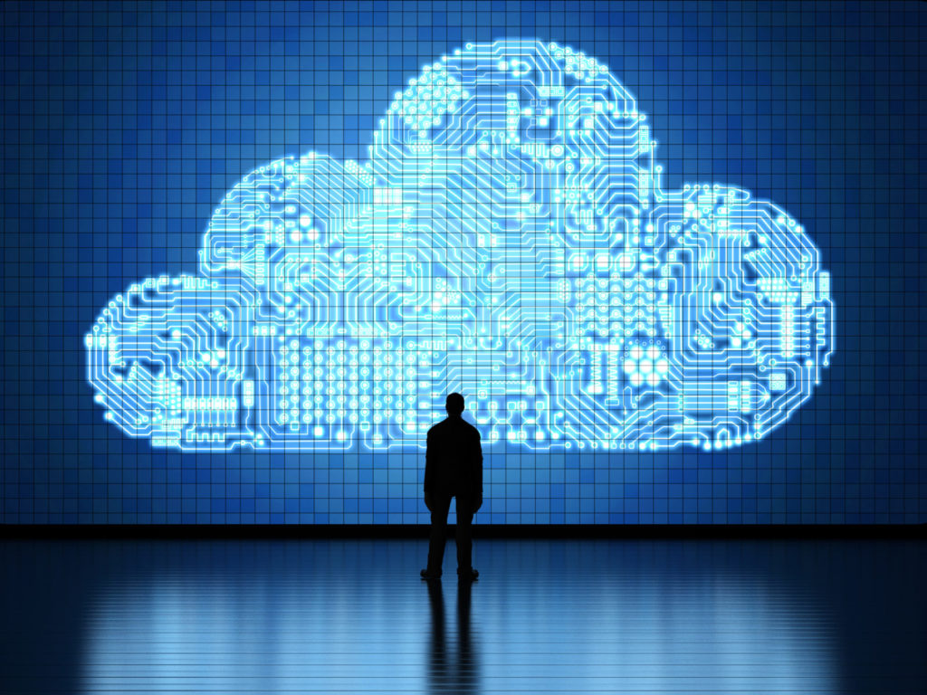 A silhouette stands in front of a cloud shape representing cloud-native or cloud computing