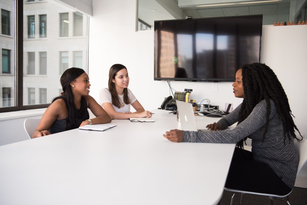 an african american candidate is being interviewed by two young professional women